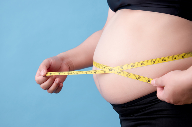 portrait-of-an-overweight-woman-measuring-her-belly